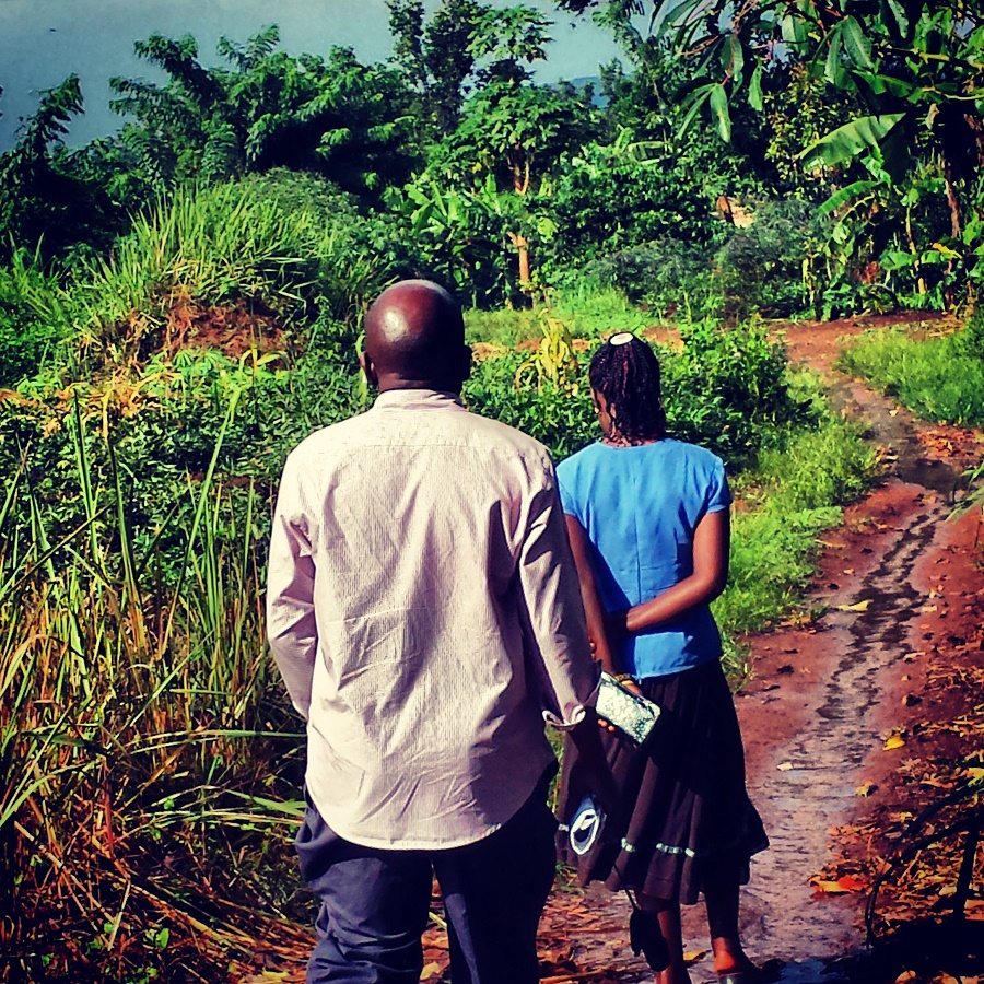 Joseph being led by local, Nakalema Rosemary, to the homes of these children