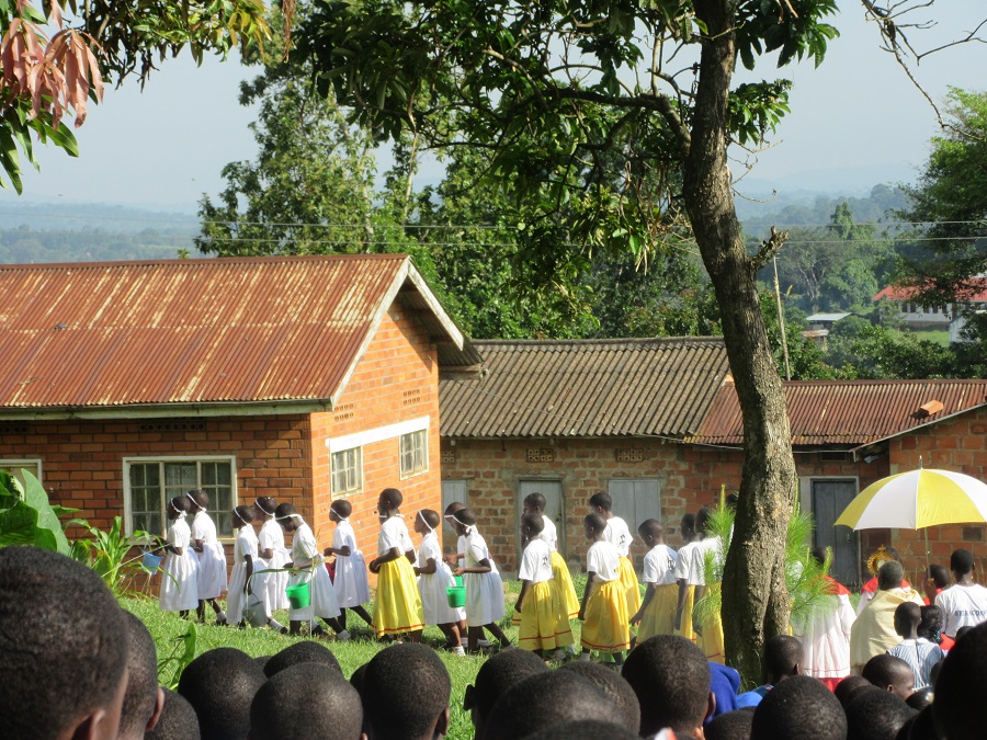 The procession was led by primary school girls in white dresses carrying green buckets filled with flower petas and leaves which they sprinkled at various locations. The procession was led by primary school girls in white dresses carrying green buckets filled with flower petas and leaves which they sprinkled at various locations.