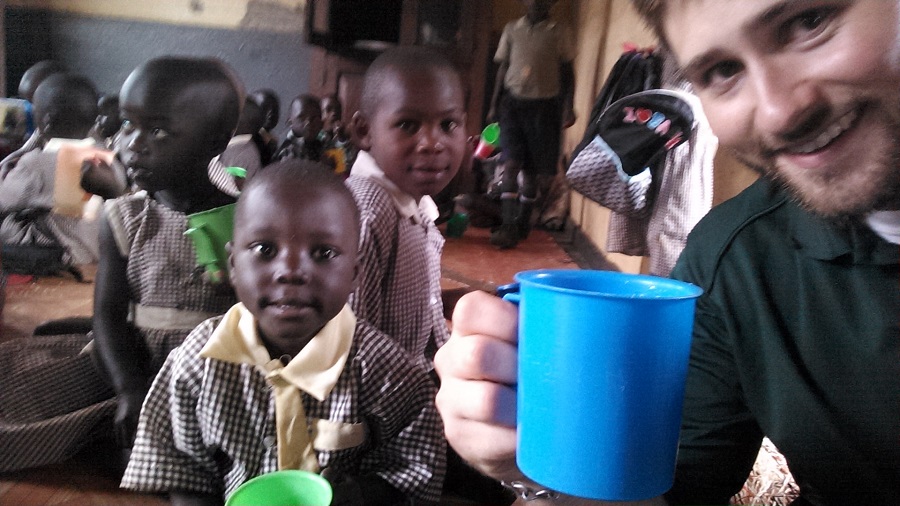 Kollin, CARITAS For Children Theology Content Writer, enjoys a serving of porridge with St. Anthony students. Kollin, CARITAS For Children Theology Content Writer, enjoys a serving of porridge with St. Anthony students.